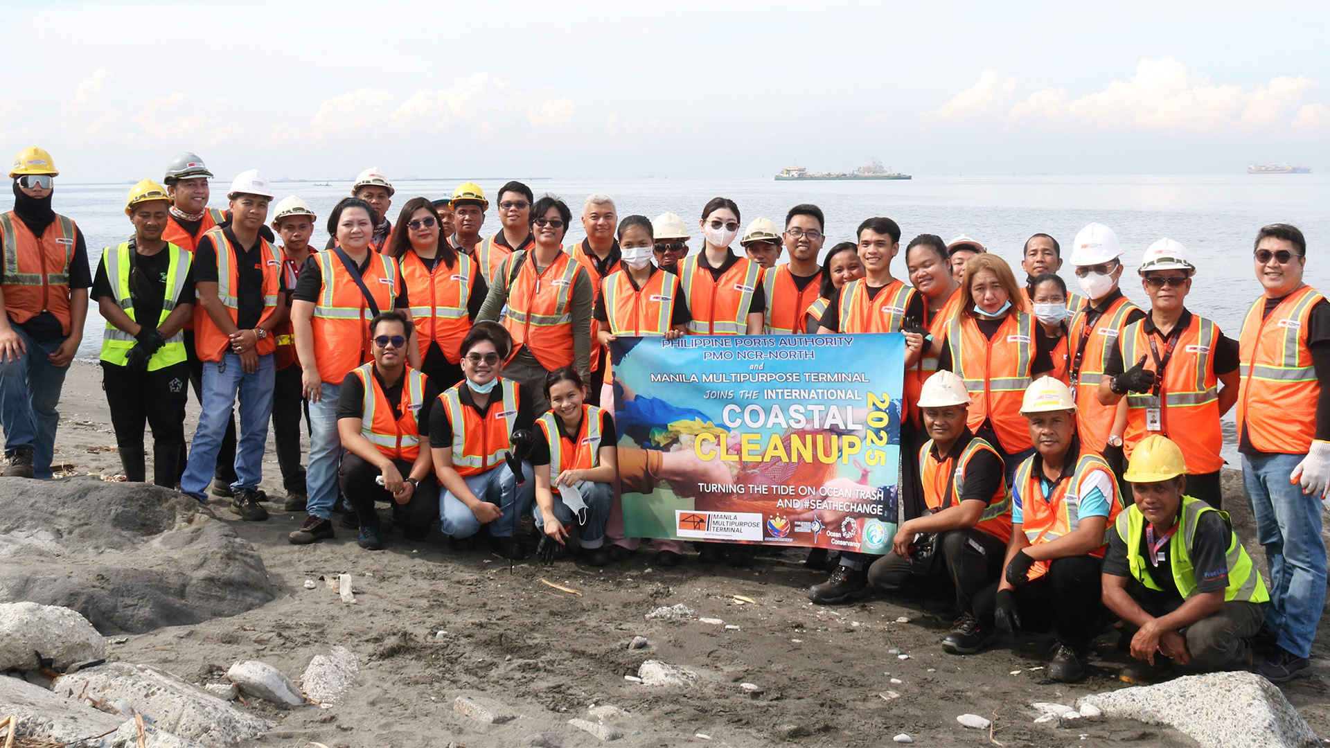 Volunteers posing in the shoreline after coastal cleanup